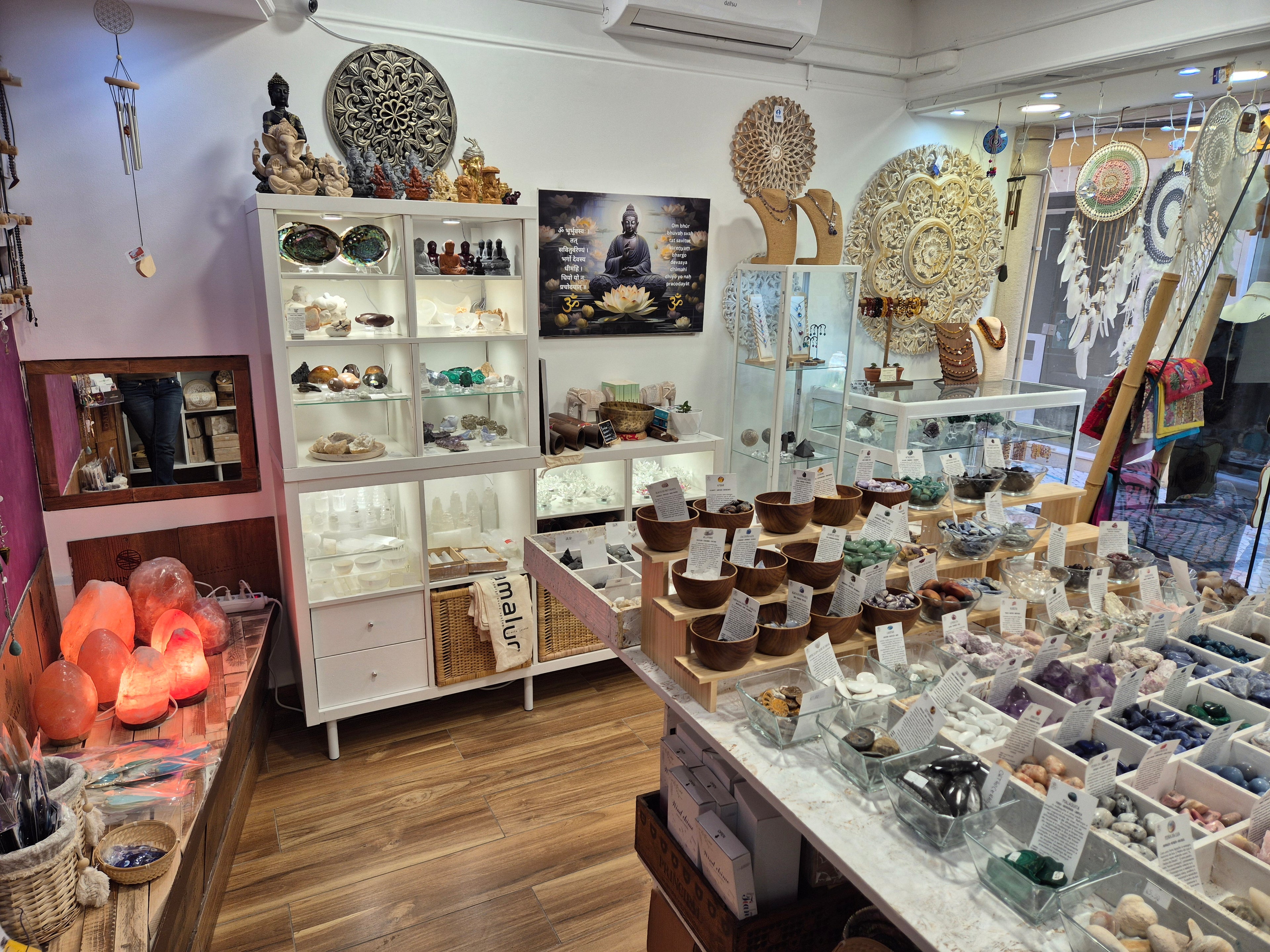 Cozy spiritual shop with crystals, Buddha statues, Himalayan salt lamps, and dreamcatchers for zen decor and healing.