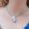 Necklace with a stone pendant and amazonite beads on a person's neck