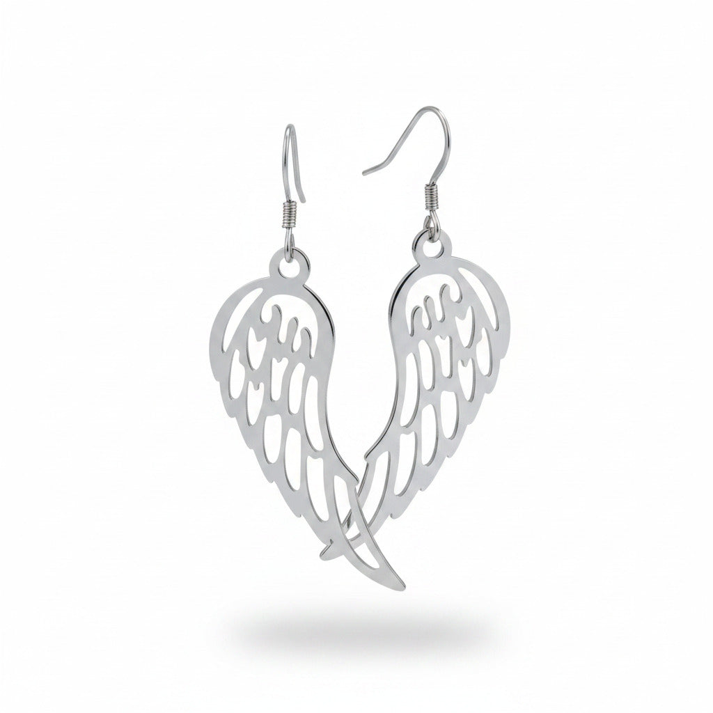 Pair of silver wing-shaped earrings on a beige background