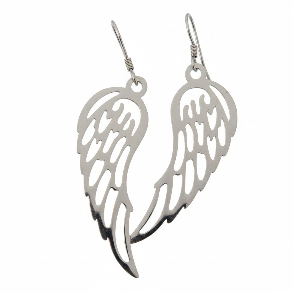 Pair of silver angel wing earrings on a beige background