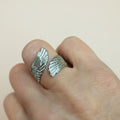 Angel wing ring on finger with white background