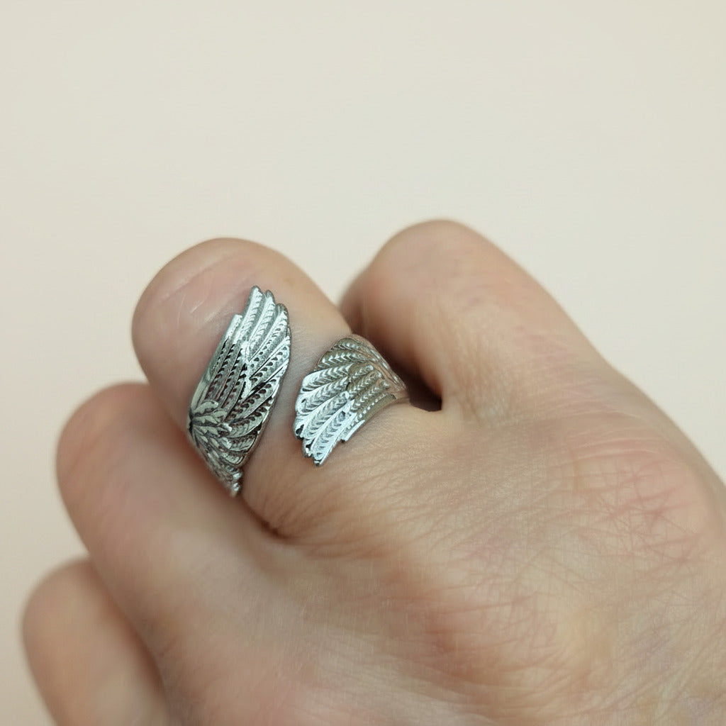 Angel wing ring on finger with white background