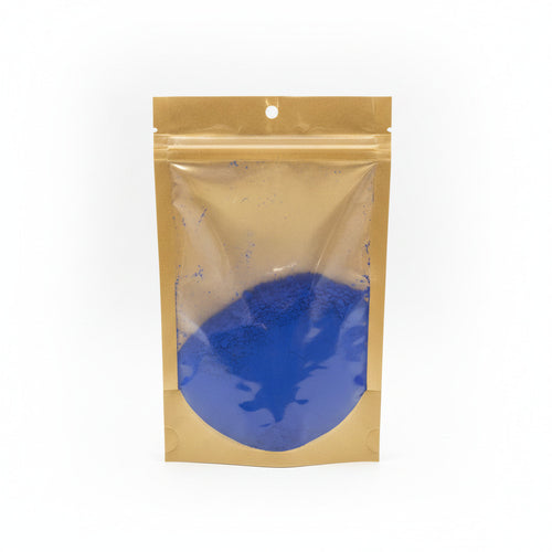 Clear plastic bag with blue powder inside on a white background