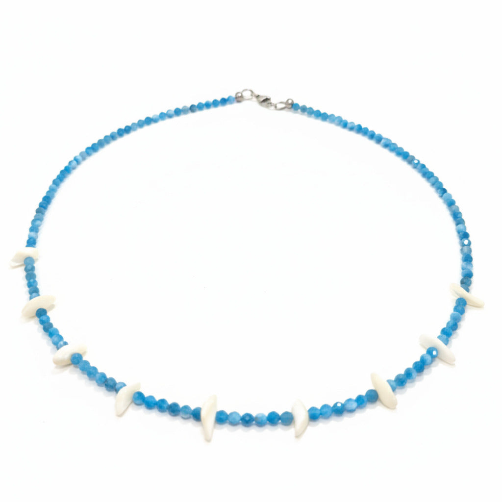 A beaded necklace with small blue faceted beads and alternating white shell-like accents, displayed on a white background.