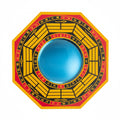 Circular object with yellow and red design, with mirror in center on a white background