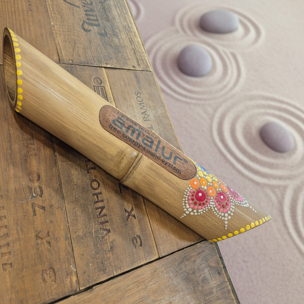 Decorative bamboo speaker with painted floral design on a wooden surface