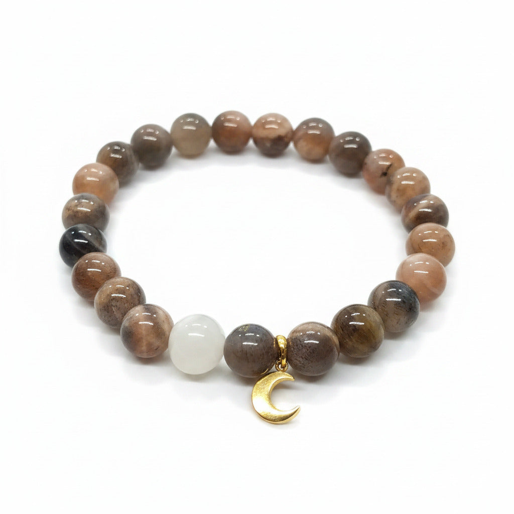 Beaded bracelet with brownish beads and golden moon charm on a white background
