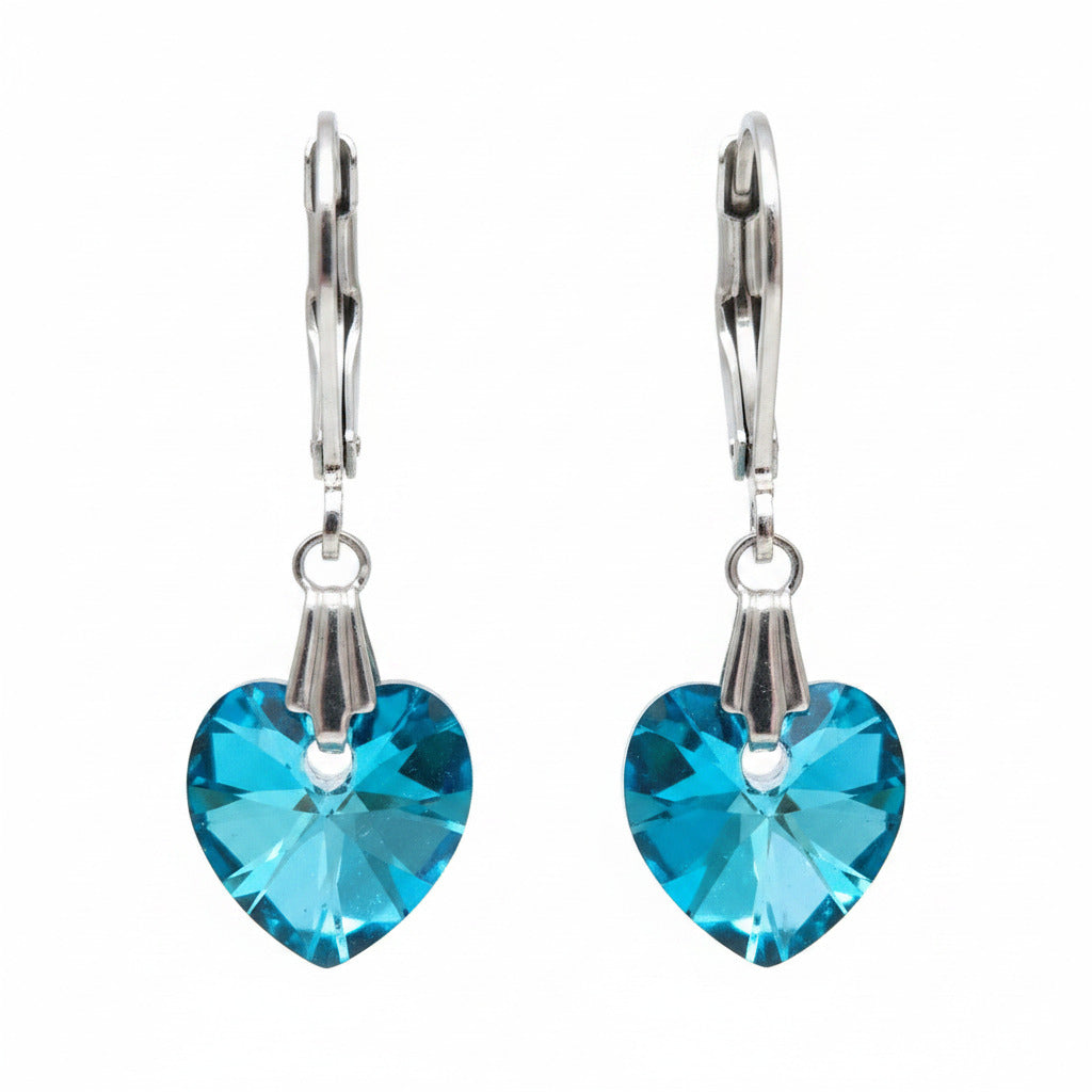 Pair of earrings with blue heart-shaped swarovski crystal on a white surface