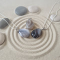 Agate stone pendants on a sandy surface with chain