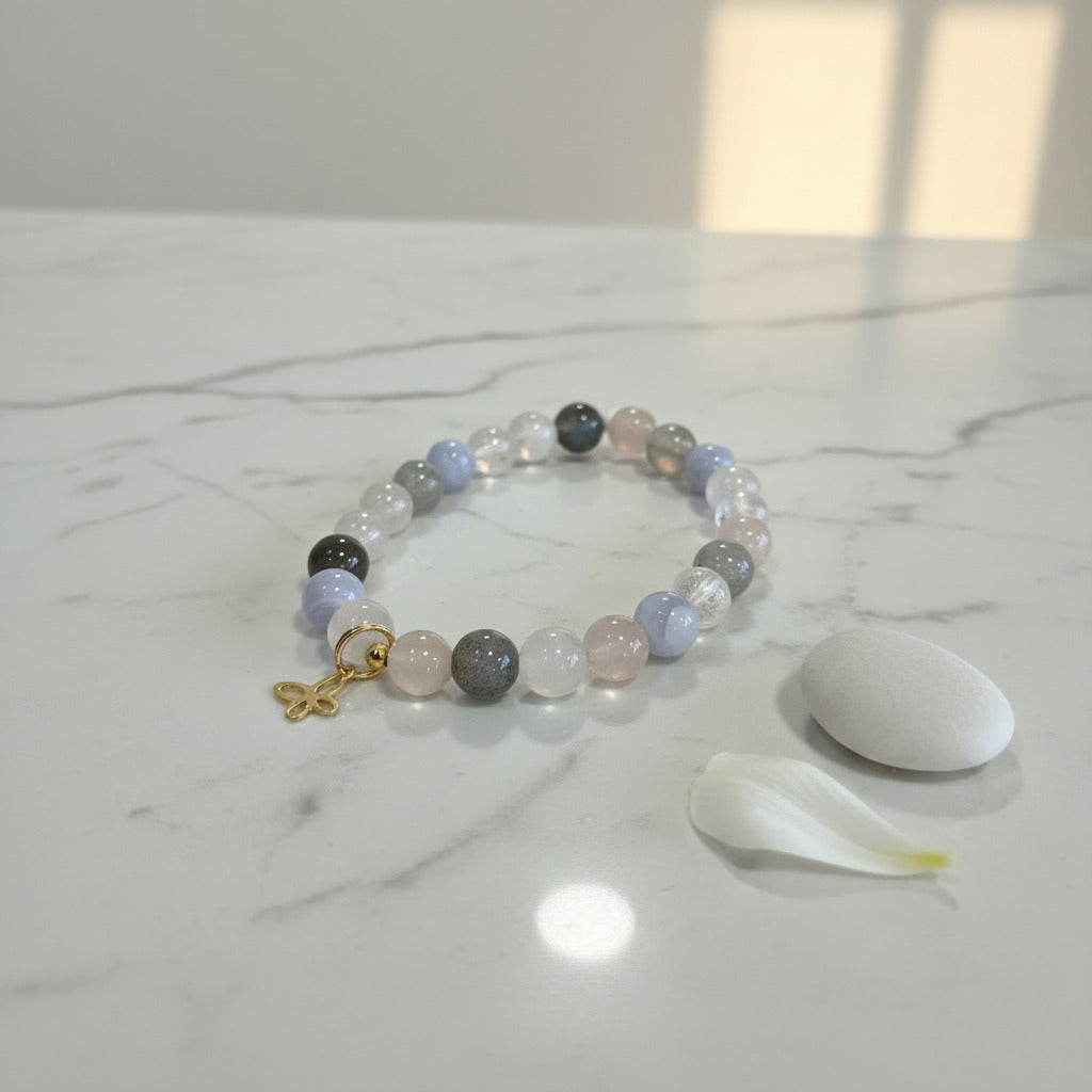 Gemstone bracelet with pastel beads and gold charm on marble, ideal for zen meditation and mindfulness