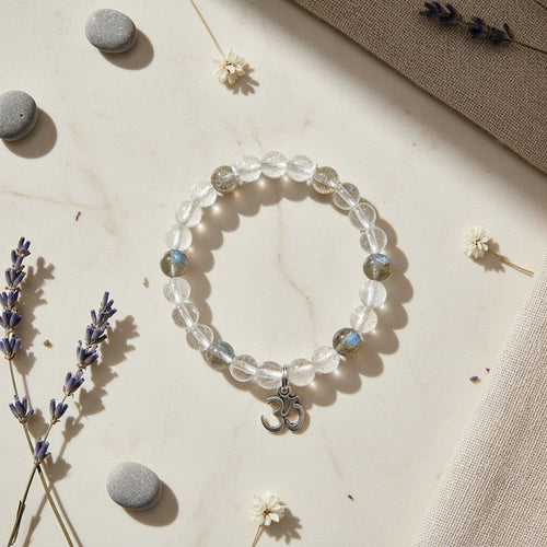 Crystal bracelet with OM charm on a neutral background with lavender and stones