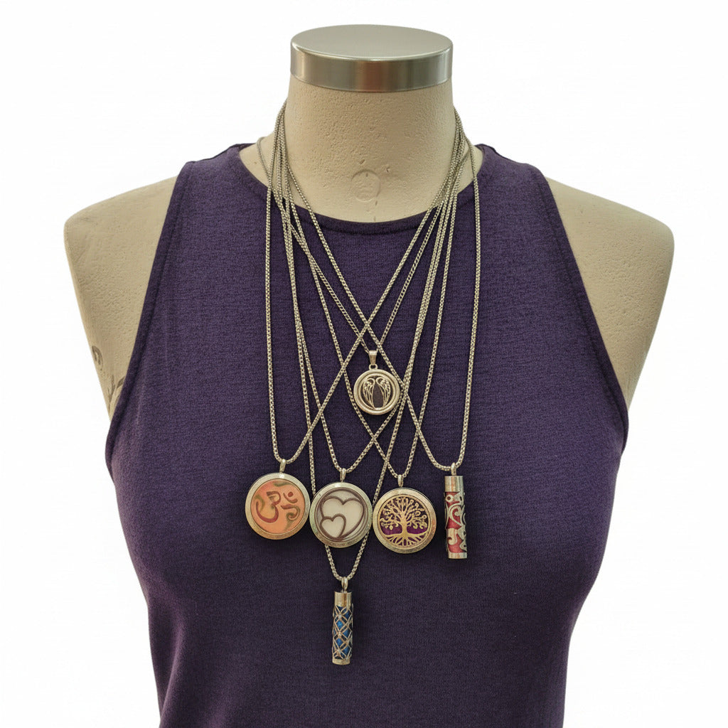 Set of necklaces with various pendants on a mannequin wearing a purple garment.