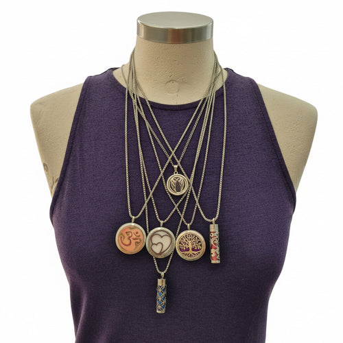 Set of necklaces with various pendants on a mannequin wearing a purple garment.