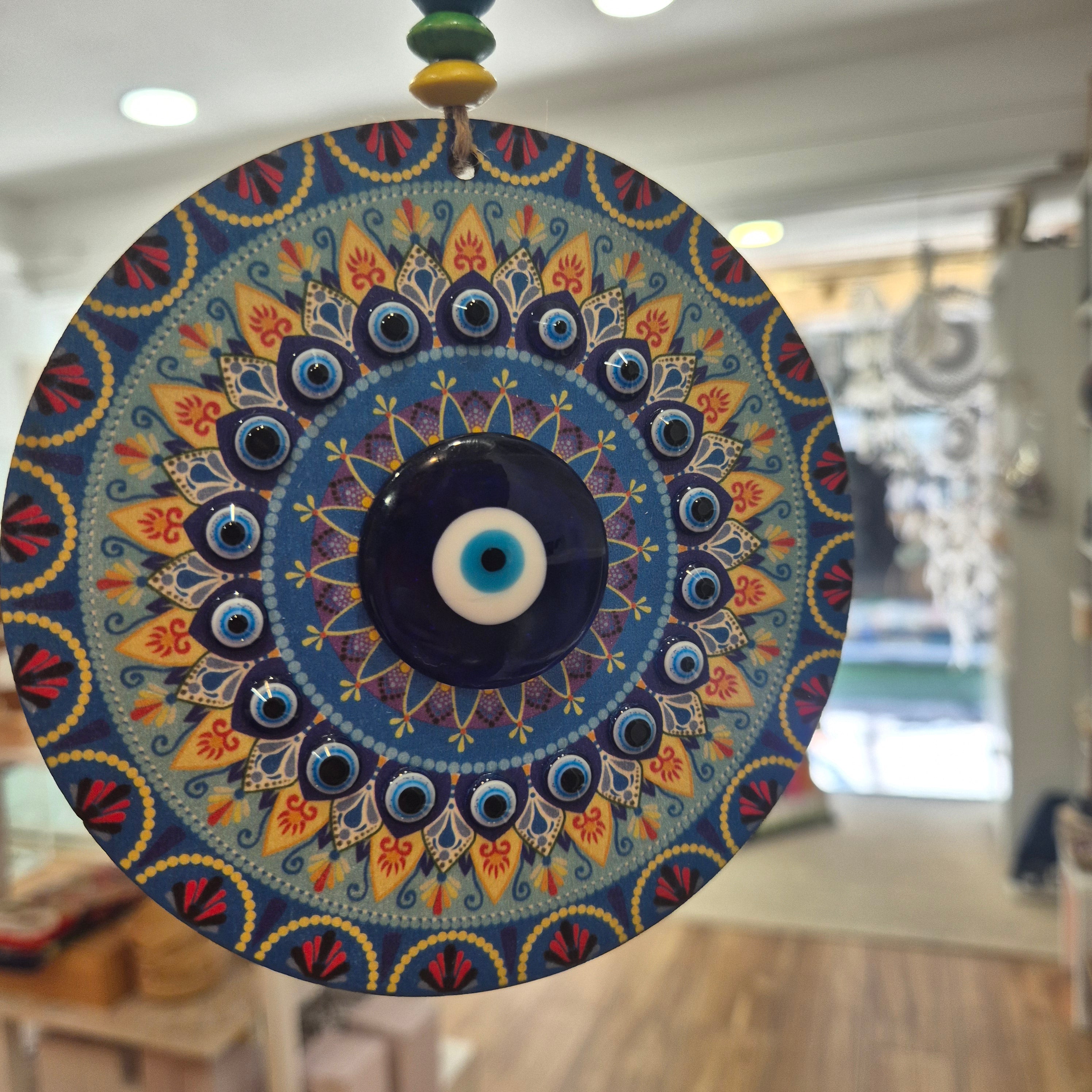 Decorative circular object with intricate patterns and colors, a wall hanging or ornament.
