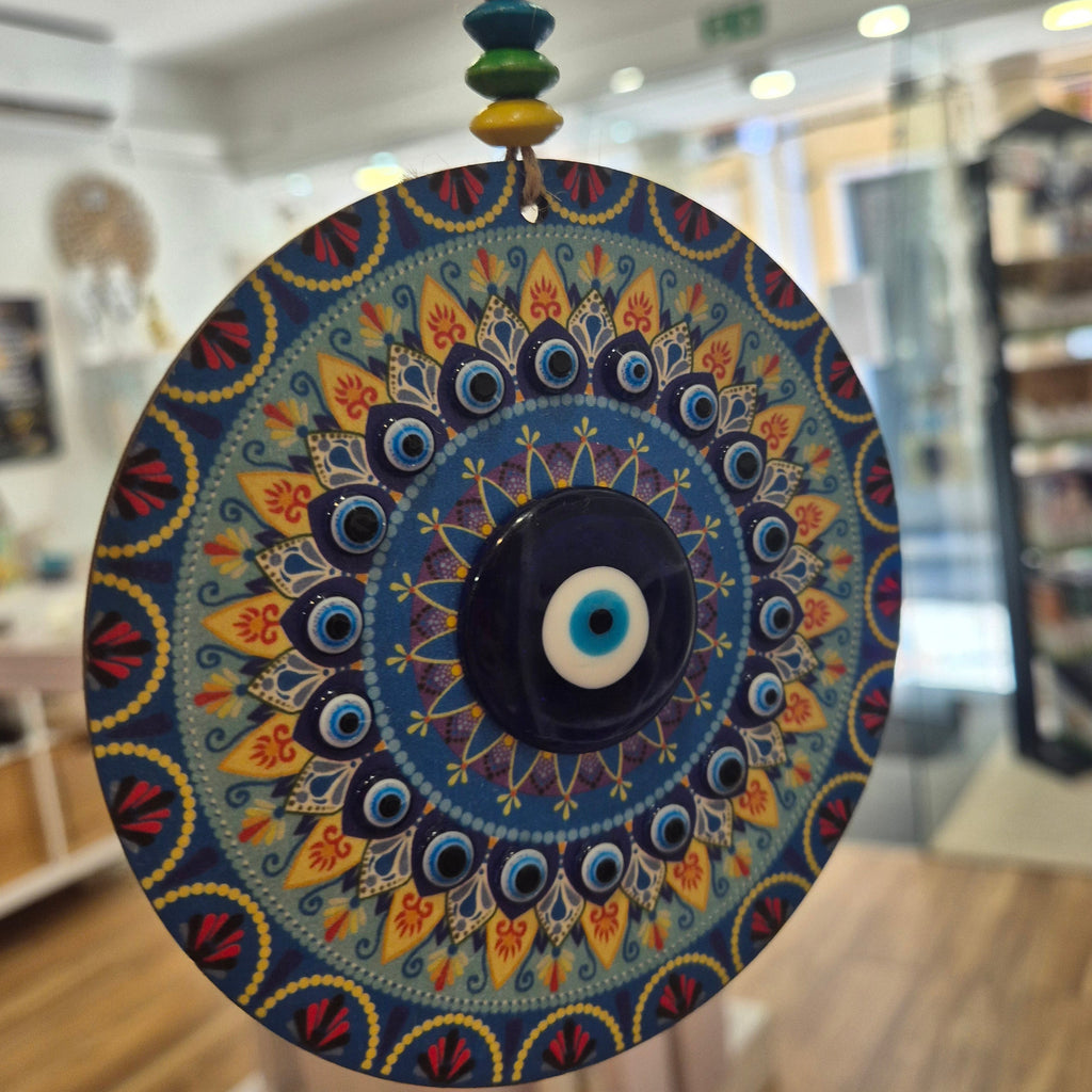 Decorative circular object with intricate patterns held in front of a blurred indoor background