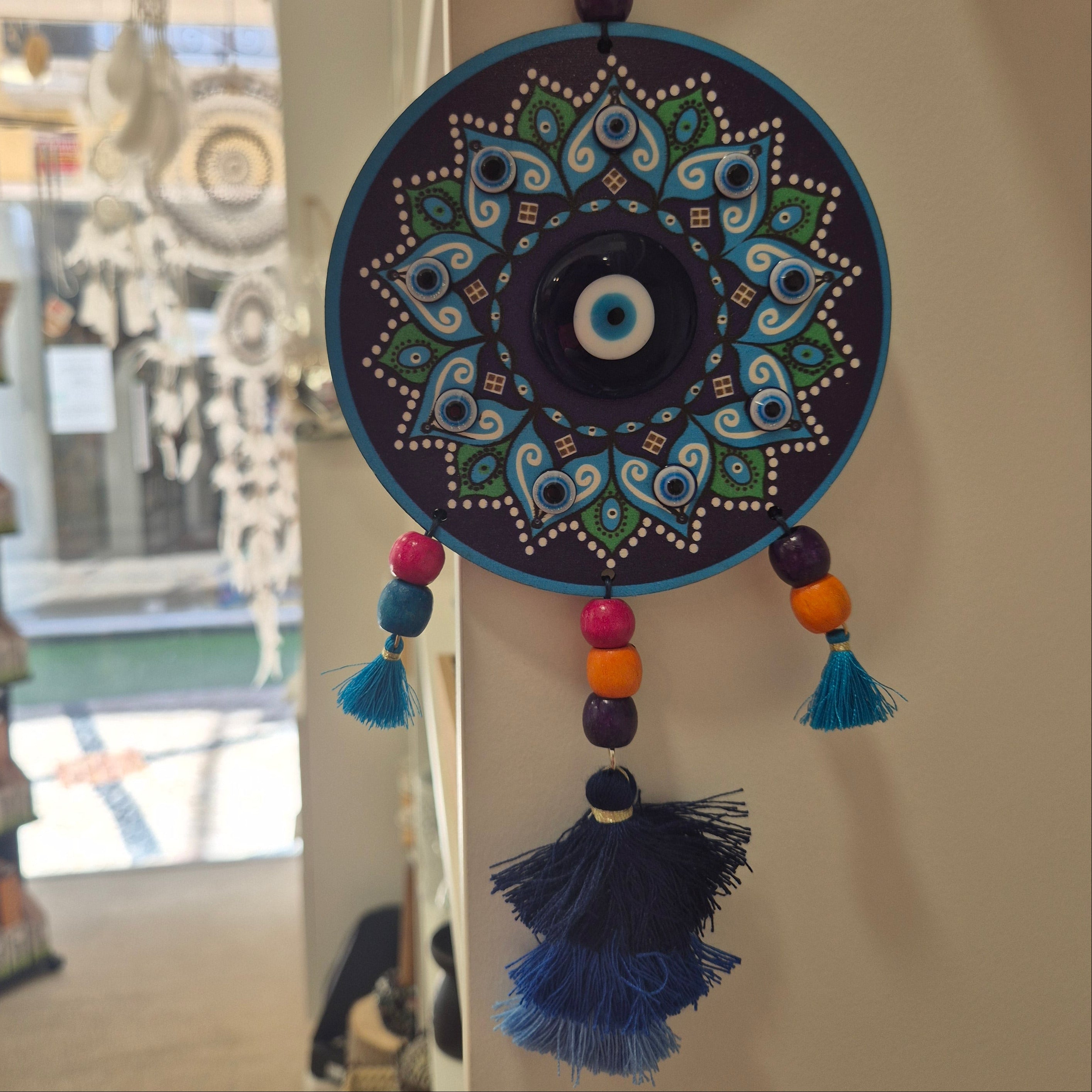 Decorative wall hanging with mandala design and tassels in a room setting