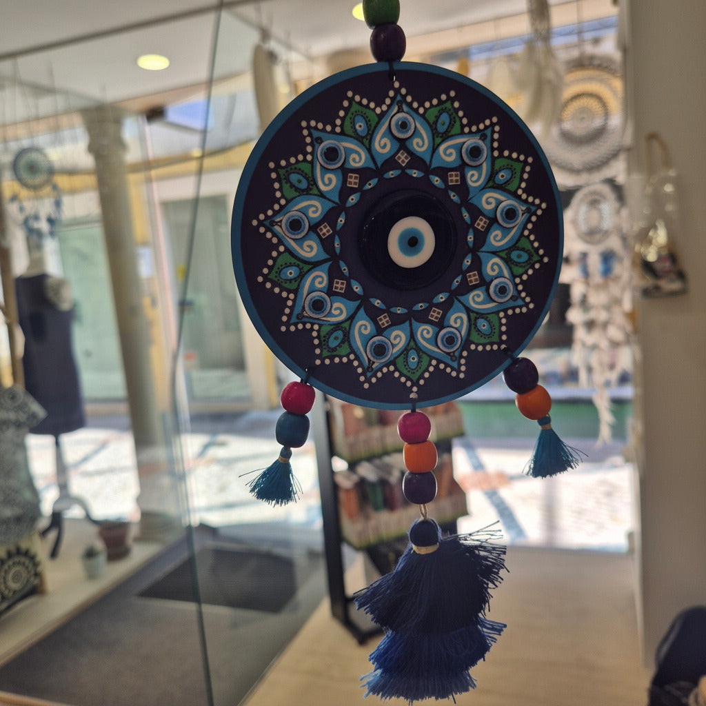 Decorative blue circular object with intricate patterns held in front of a blurred indoor background