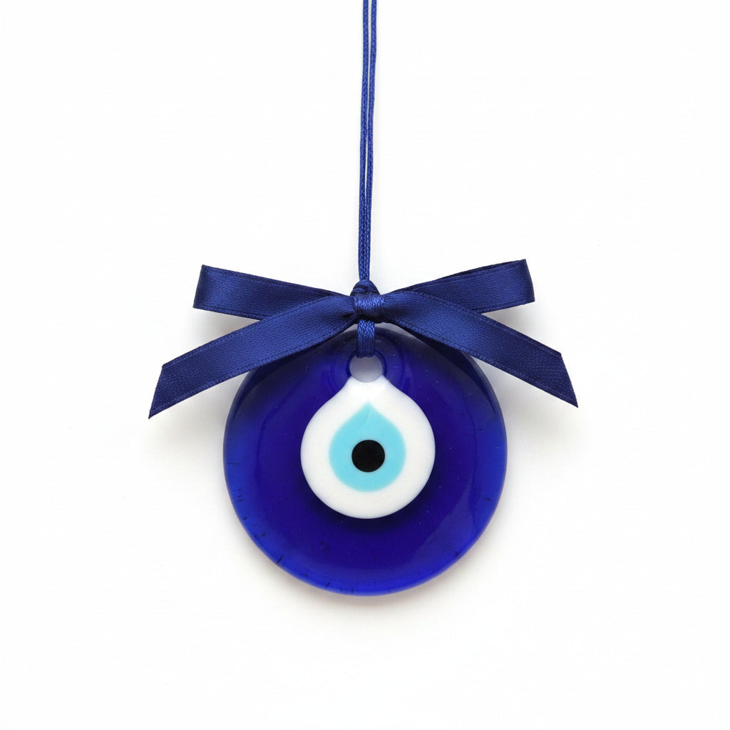 Blue evil eye pendant with a black dot and white center on a white background
