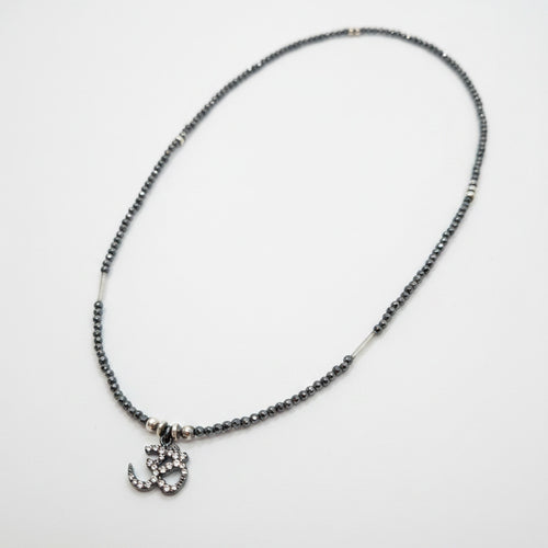 Necklace with small charm on a light gray background