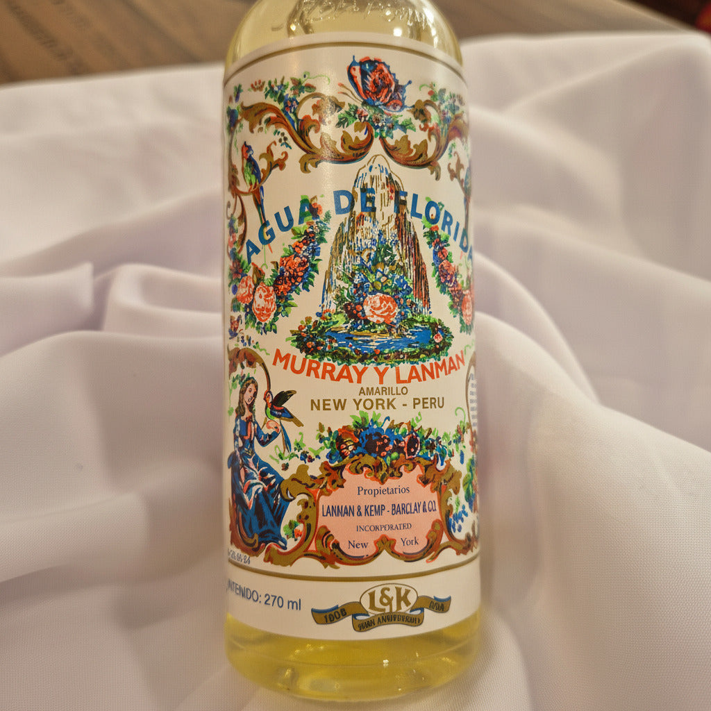 Bottle of Agua de Florida with decorative label on a white fabric background