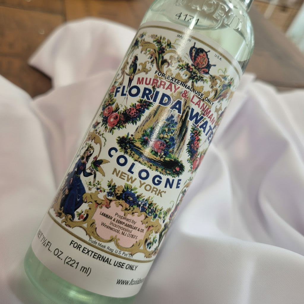 Vintage bottle of Florida Water cologne with decorative label on a white fabric background