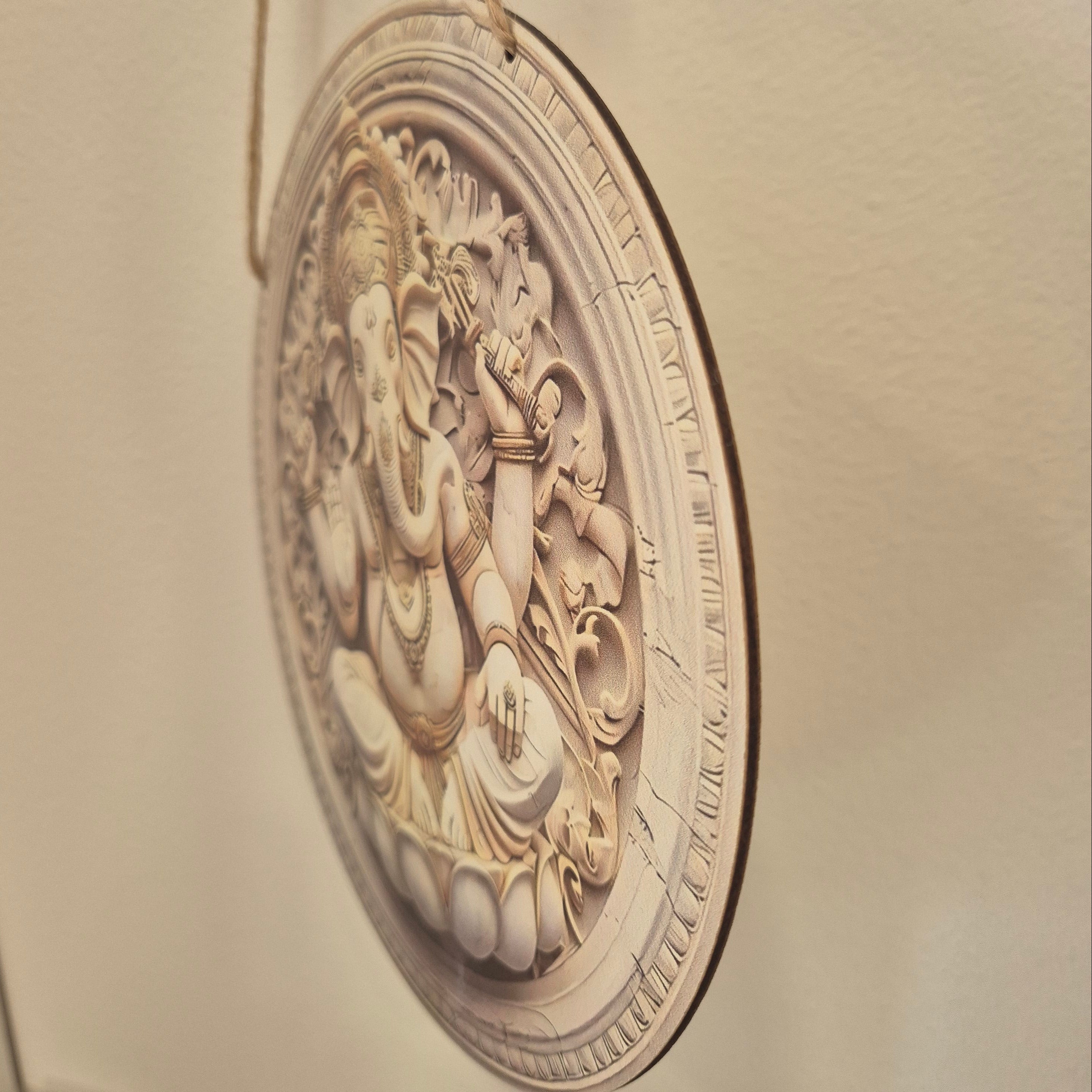 Decorative wall plaque with intricate design on a beige wall.