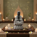 Statue of a meditating Buddha with candles and incense in a serene setting