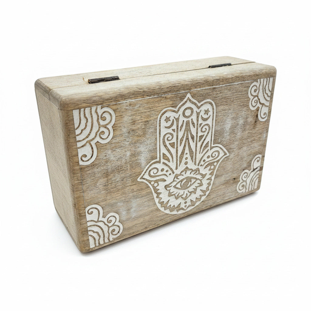 Wooden block with Hamsha hand design on a white surface