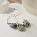 K2  jasper stone pendants on chain on a white surface