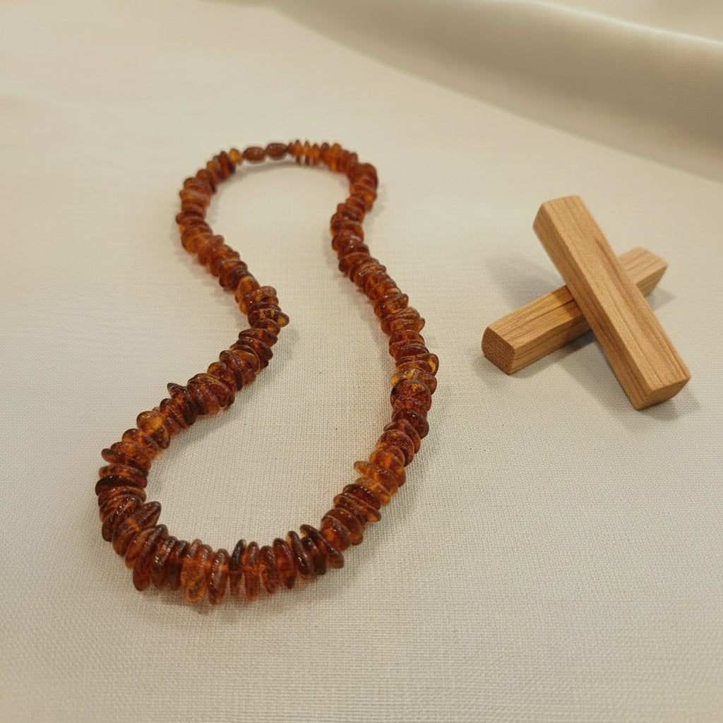 Amber necklace with palo santo on a beige fabric background