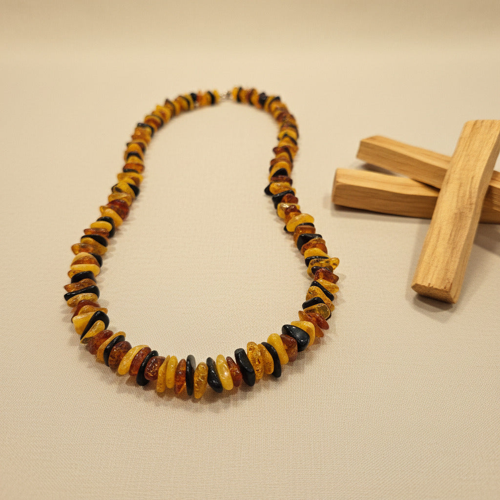 Necklace made of multicolored chip amber beads on a beige background