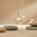 clear quartz pendant hanging on a chain in a zen environment