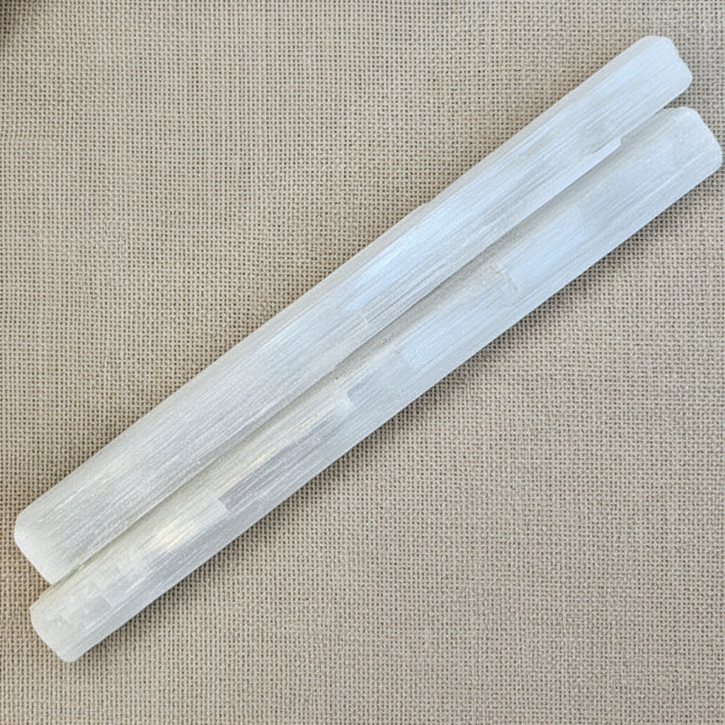large raw selenite sticks o a beige background