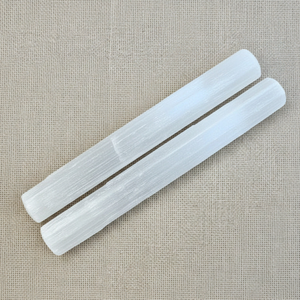 selenite sticks on a beige fabric background