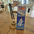 Incense stick holder with incense sticks and a box labeled '7 Ervas' on a wooden surface.