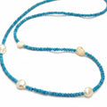 A beaded necklace featuring small, faceted turquoise-blue beads with irregular, cream-colored baroque pearls spaced along the strand, displayed on a clean white background.