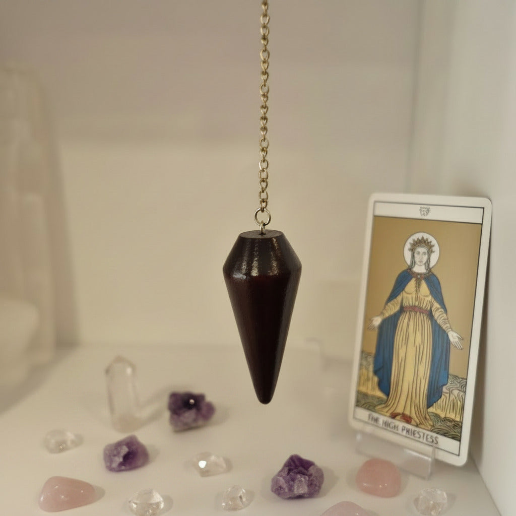Wooden pendulum hanging on a chain against a blurred background