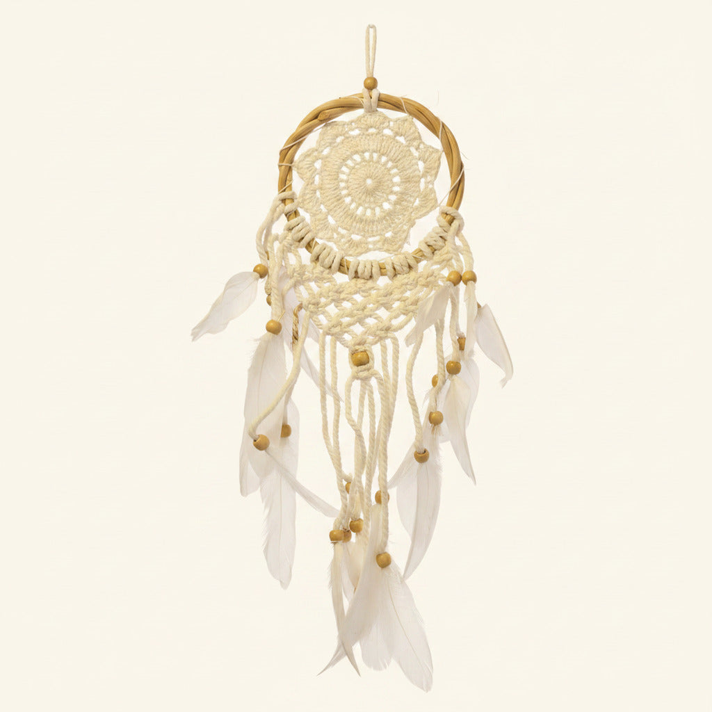 White dreamcatcher with feathers on a beige background