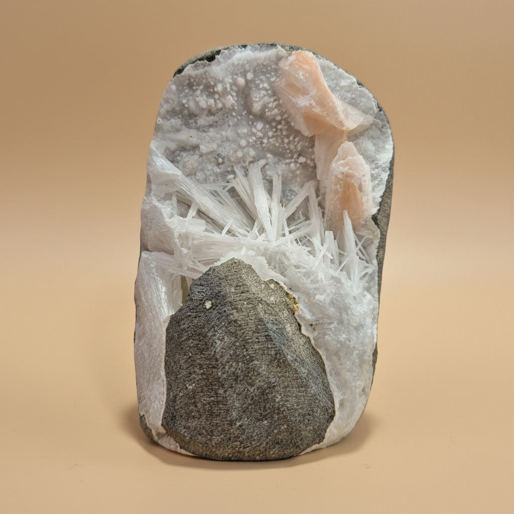 Mineral sample with crystal formations on a beige background