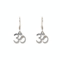 Pair of Om symbol earrings on a black earring holder against a beige background