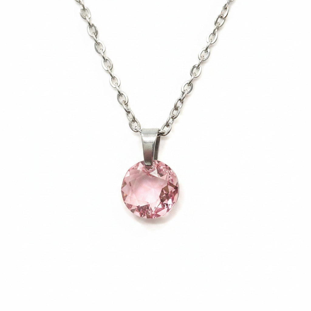 Pink crystal on silver color necklace on a plain background