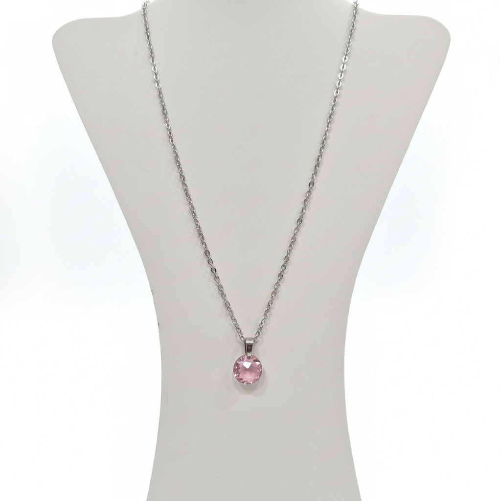 Necklace with a pink pendant on a white display withe white background