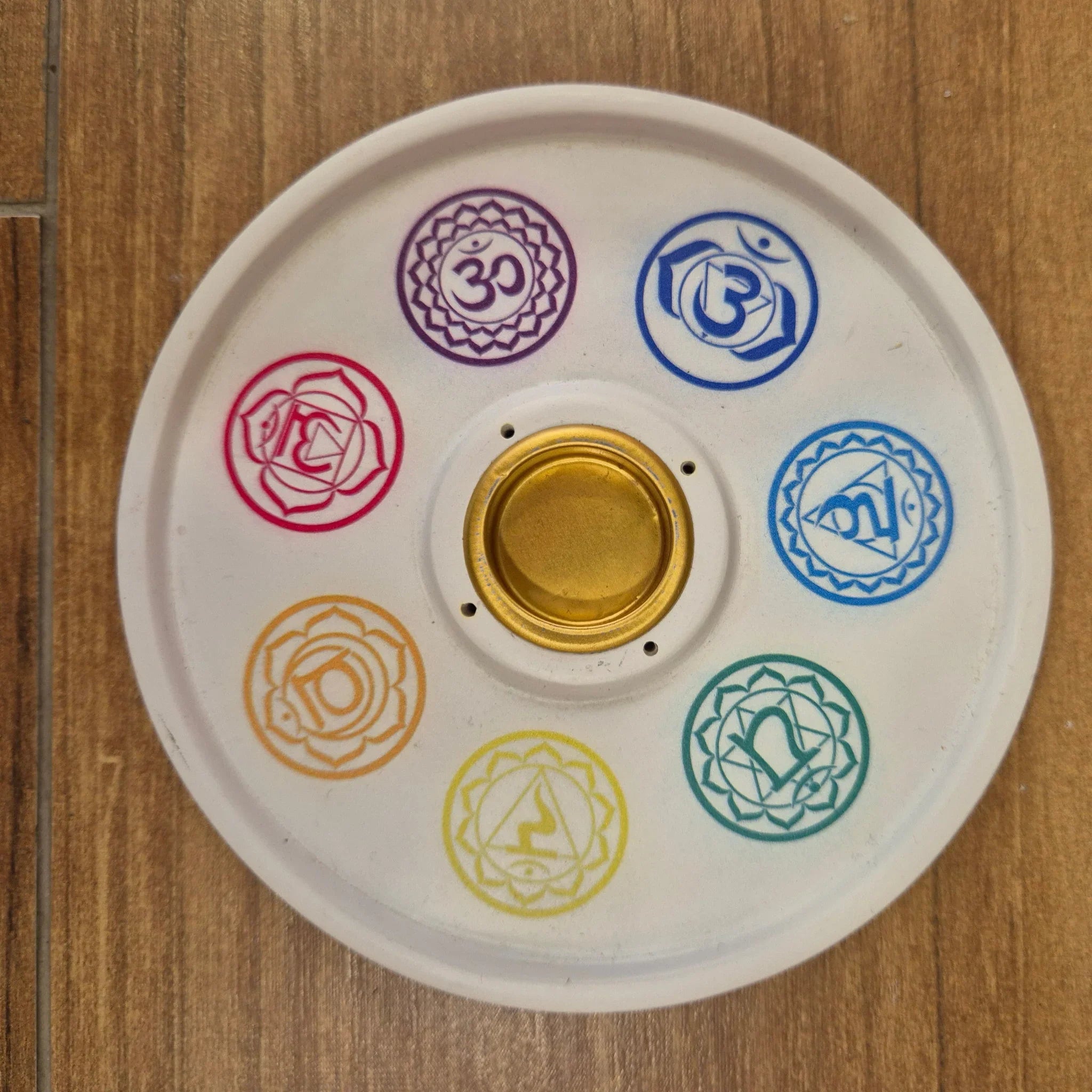 Decorative plate with colorful symbols on a wooden surface