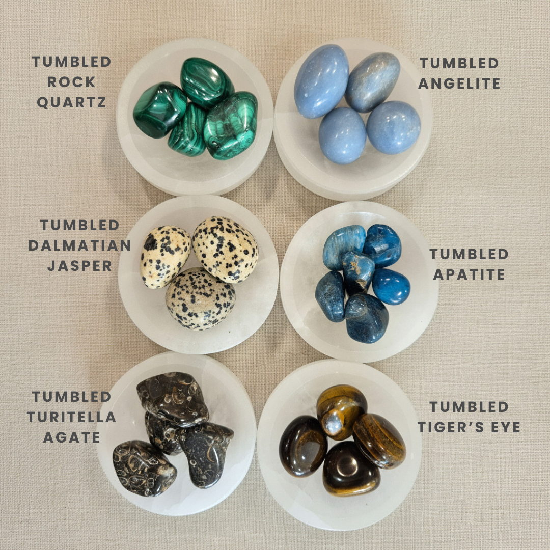 Collection of tumbled gemstones in white bowls on a beige background