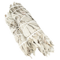 Bundled sage sticks tied with white string on a white background
