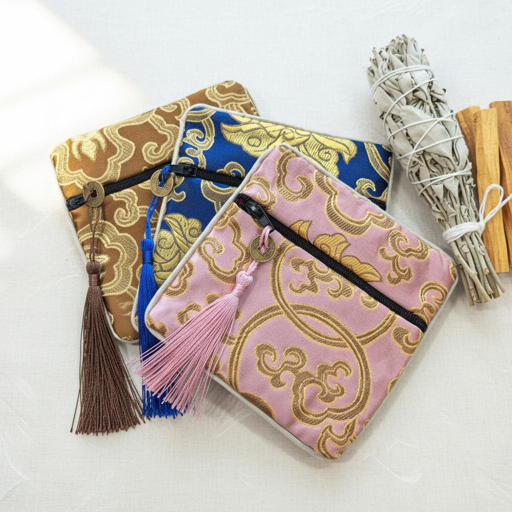 Three decorative pouches with tassels on a white background