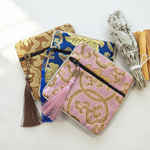 Three decorative pouches with tassels on a white background